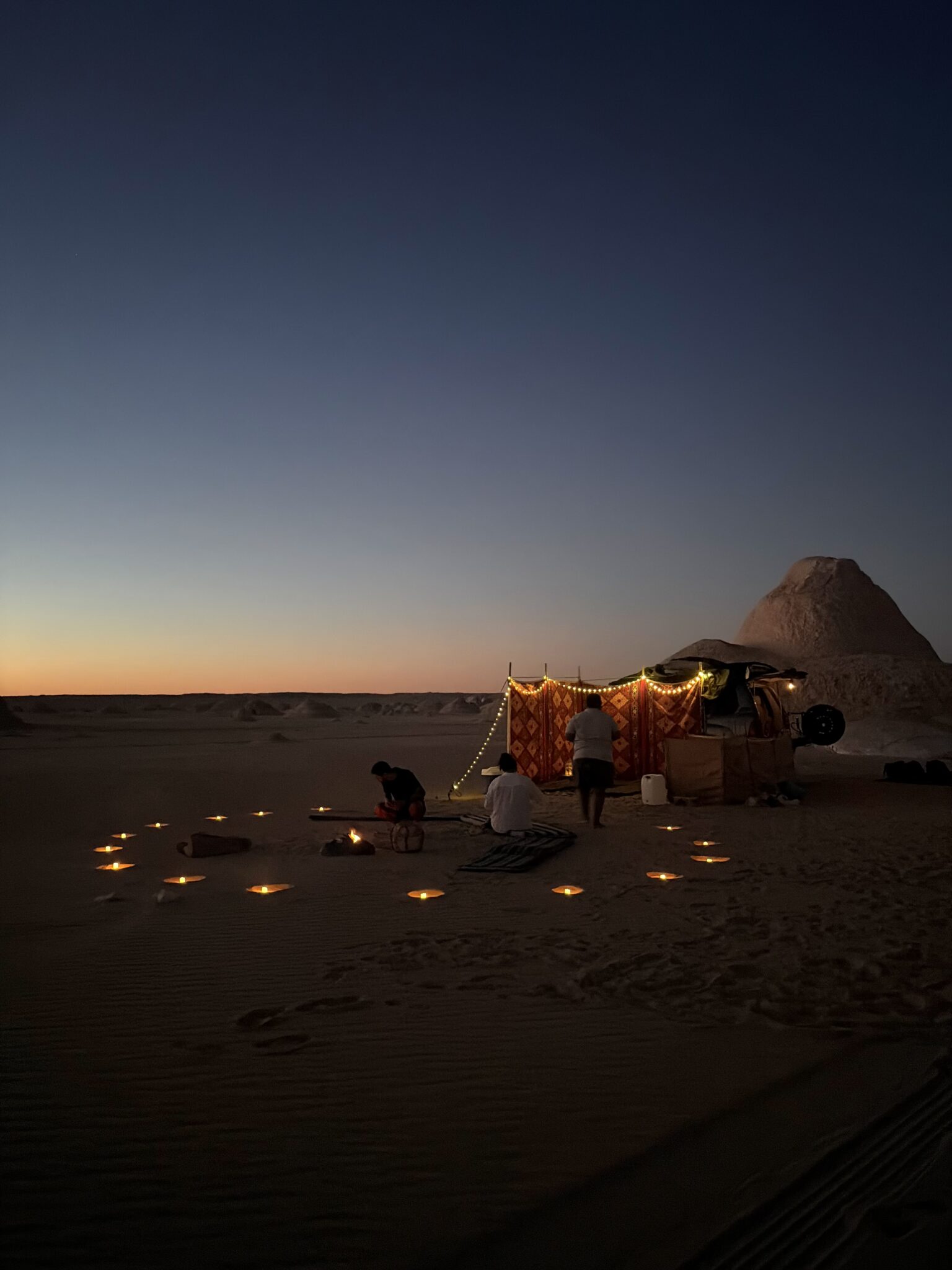 Illuminated White Desert campsite at twilight in Egypt